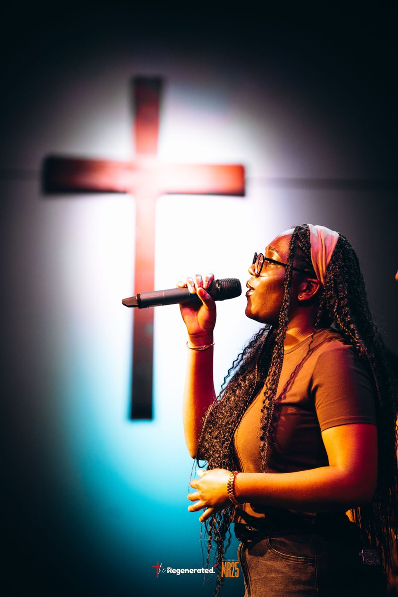 Vocalist singing in front of the cross